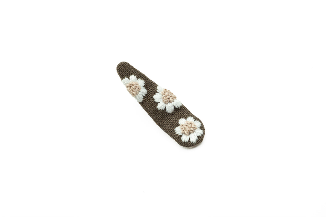 A handcrafted cocoa brown hair clip with white floral embroidery