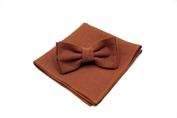 Rust linen butterfly bow tie placed on matching pocket square for men’s formal wear