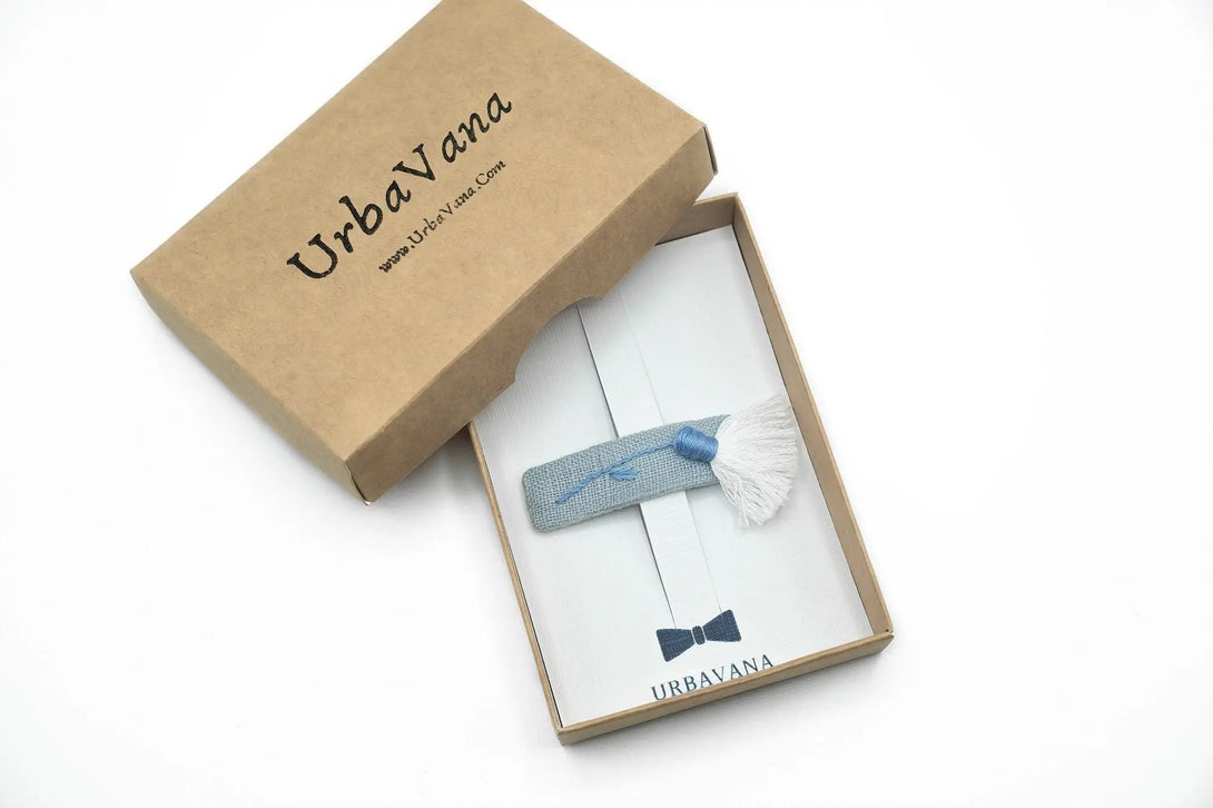 Dusty blue hair clip featuring floral embroidery and a tassel design, displayed in an elegant UrbaVana packaging, a unique accessory for girls and women