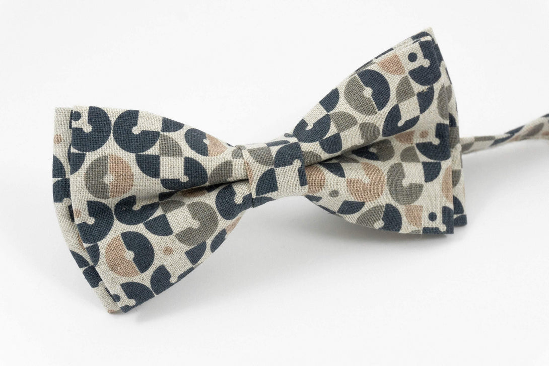 Pre-tied linen bow tie featuring a retro geometric pattern in beige, black, and brown tones, perfect for adding a stylish disco flair to men's formal or party attire