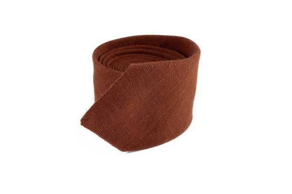 Rust groomsmen wedding necktie, shown as a brown fabric roll, offers natural elegance for weddings, available with a matching pocket square from UrbaVana.