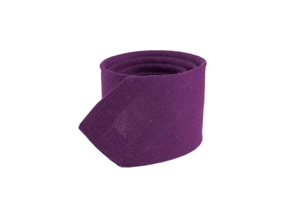 Purple handmade necktie for men, rolled up, showcasing its sleek design, perfect as a gift for grooms, available with a matching pocket square.